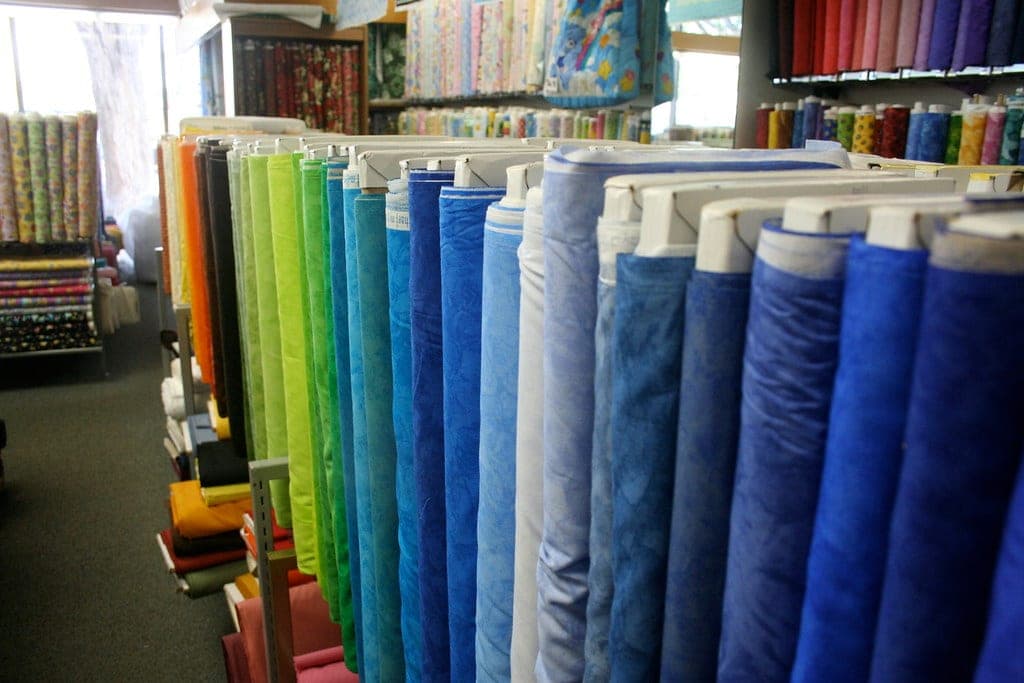 Rolls of fabric stacked on the shelves of a cloth shop