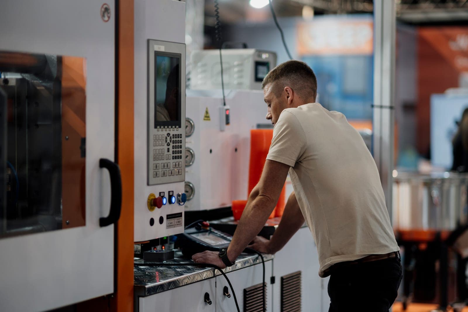 Operator working at a machine terminal on a factory production floor