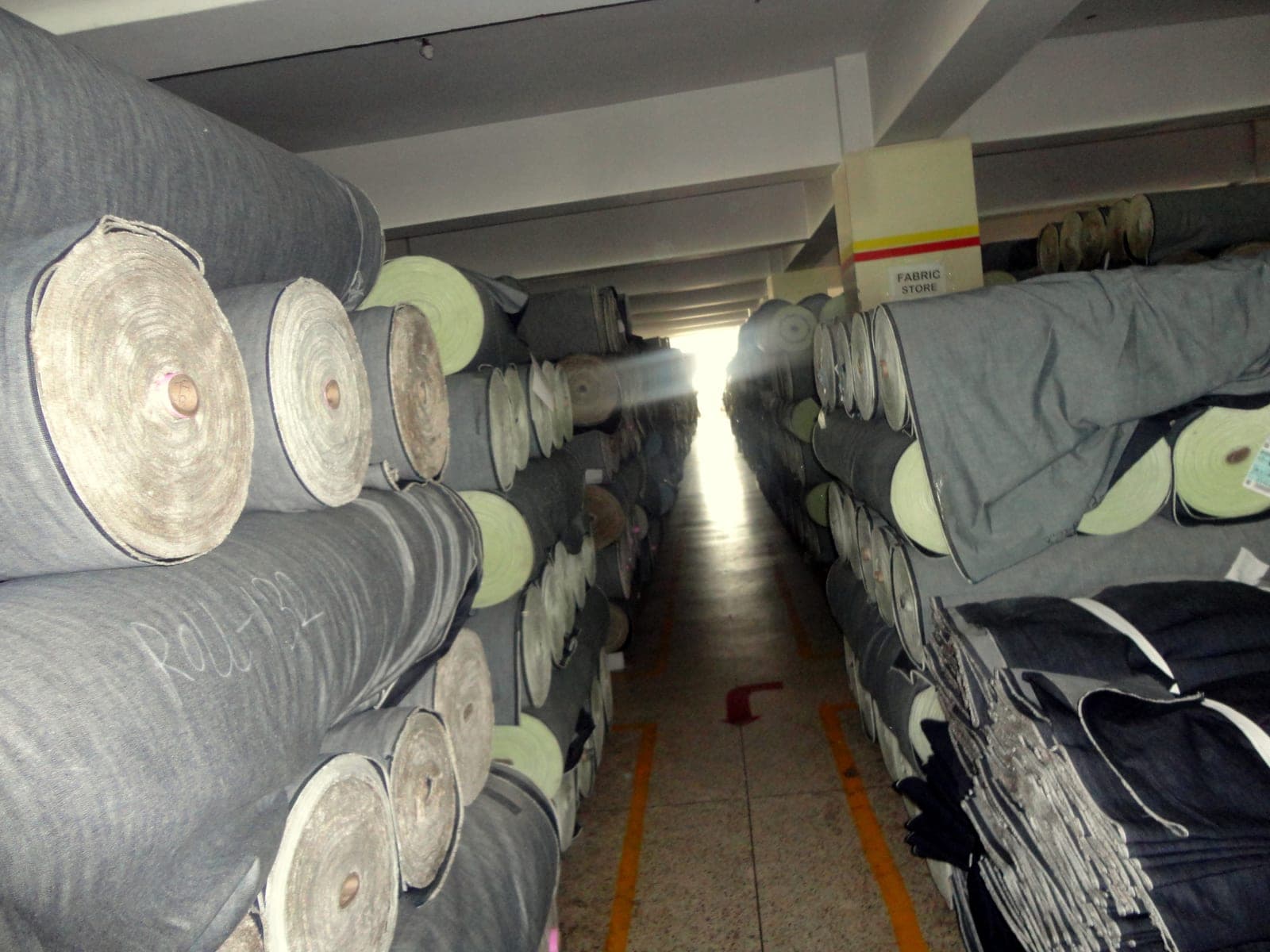 Rolls of fabric stacked in a garment factory's raw-material store