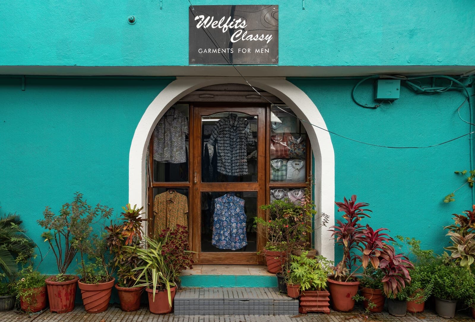 Small readymade garment shop storefront displaying men's shirts, the kind of store that needs garment billing software