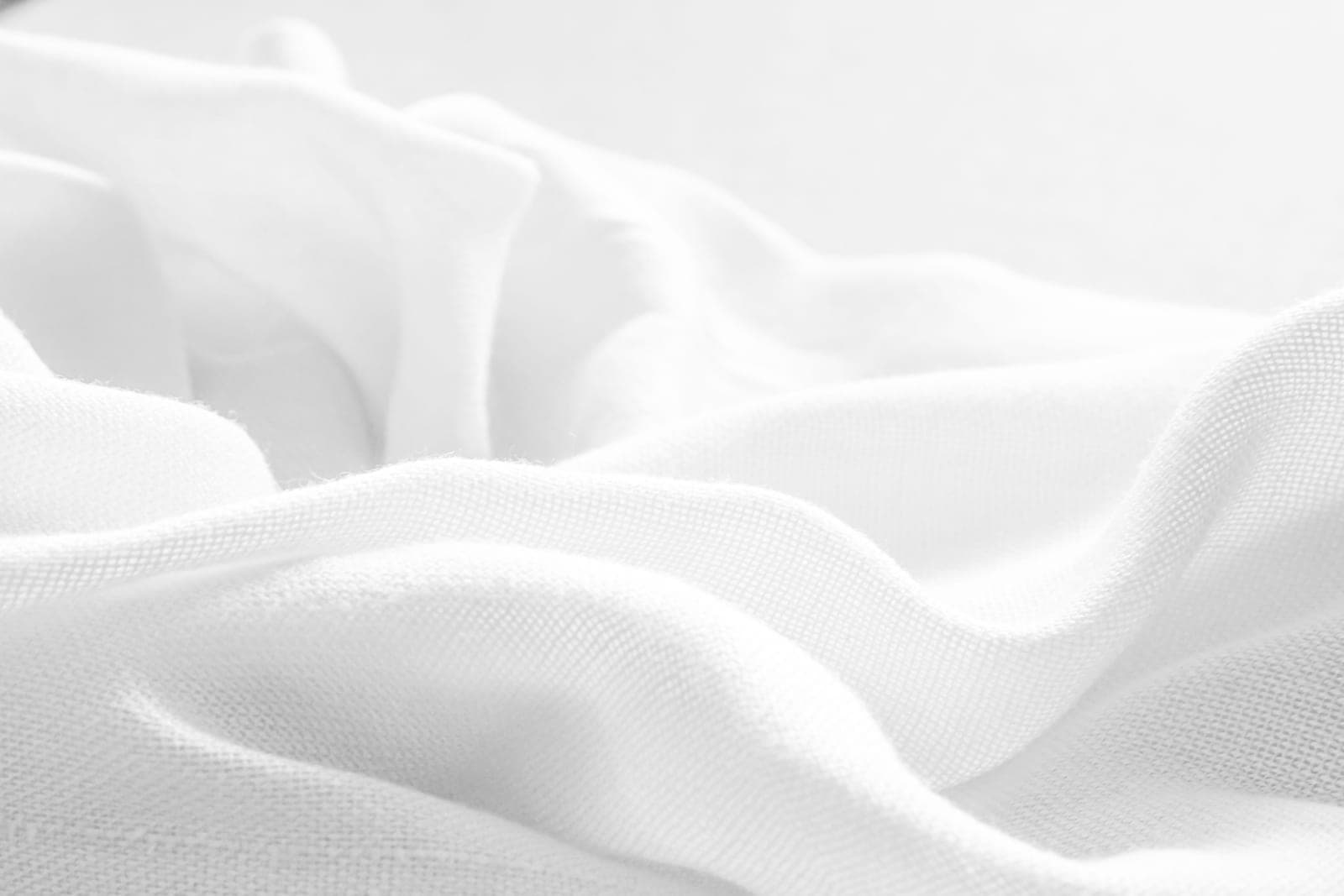 Soft white plain-weave cotton muslin fabric draped in gentle folds