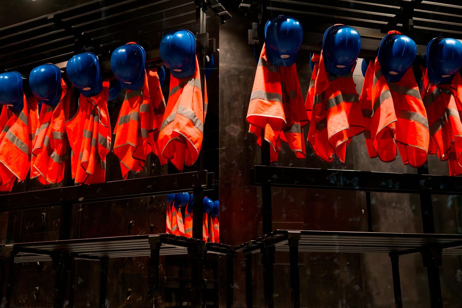 Rows of orange high-visibility safety vests and blue helmets, examples of protective technical textiles