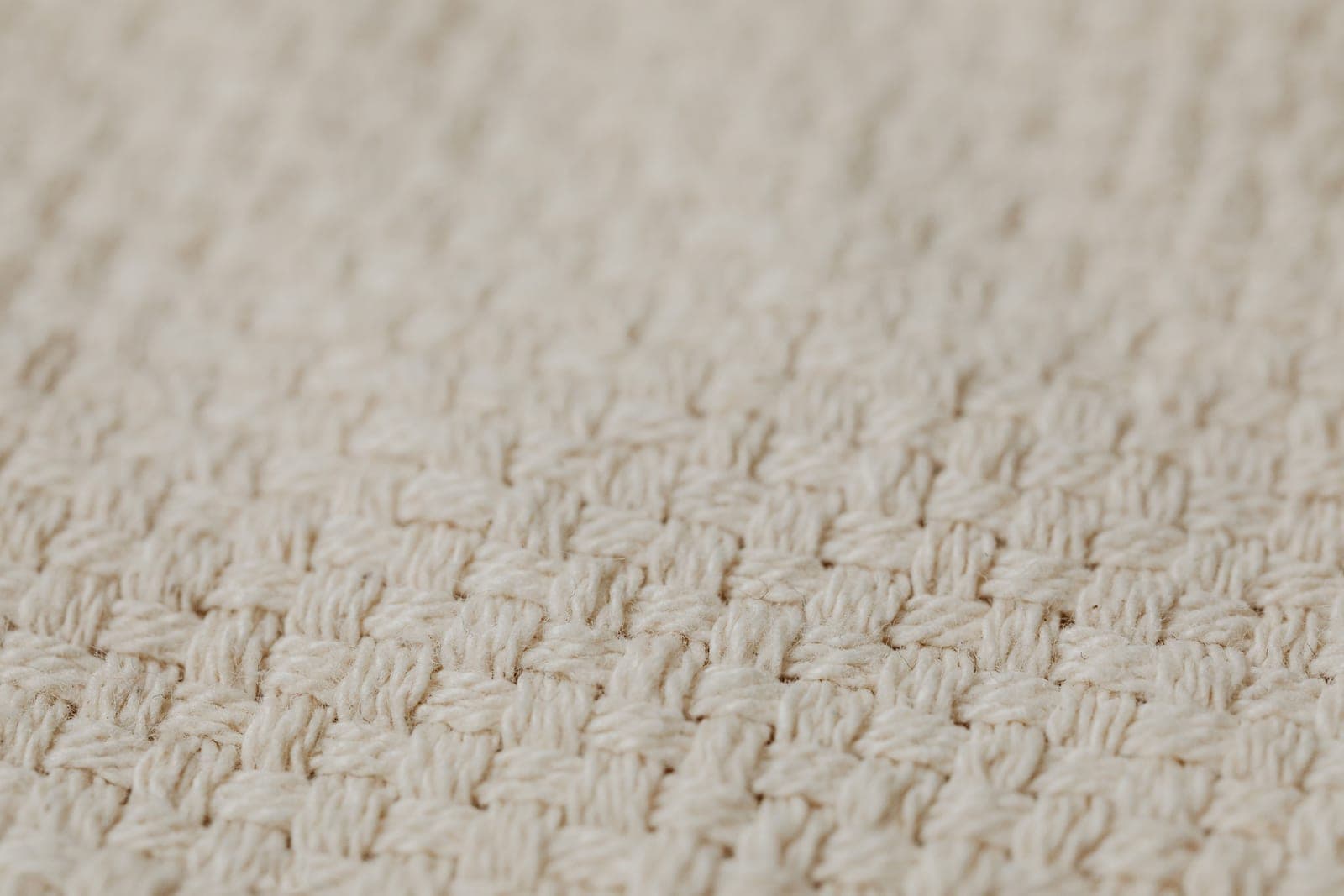 Close-up of a woven cotton fabric showing the interlaced basket-weave structure