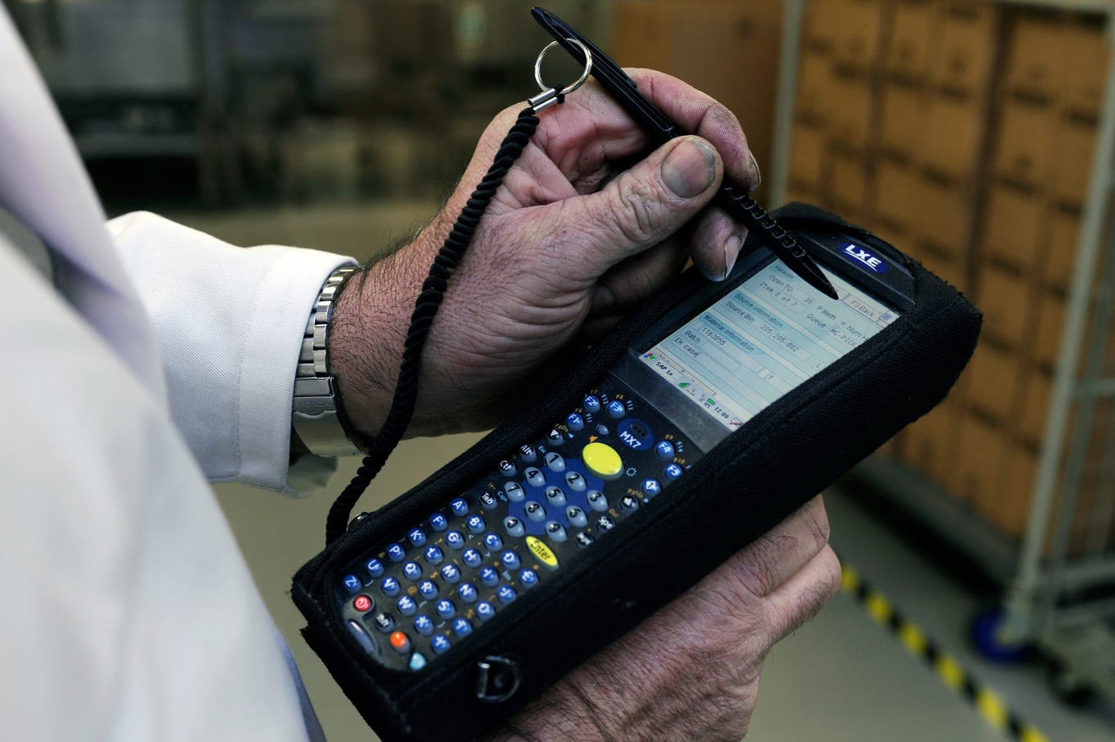 Handheld barcode scanner being used to scan stock in a warehouse