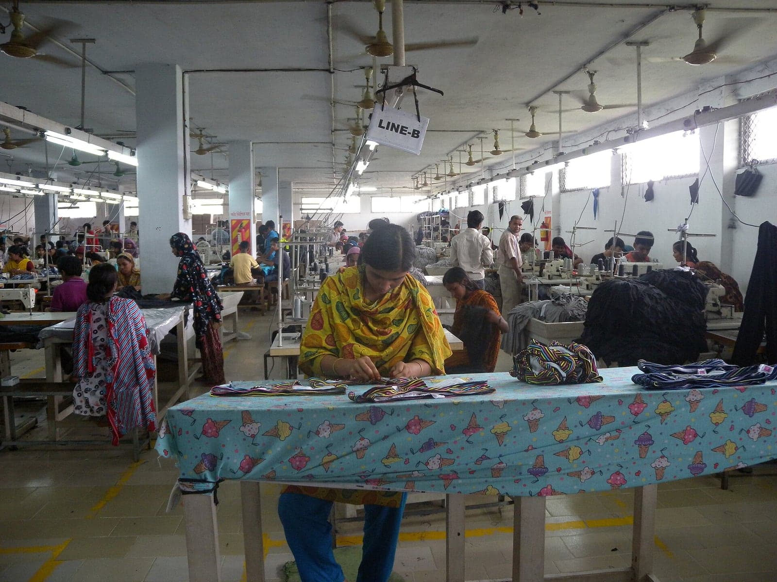 Workers on a modern textile production floor running an ERP for the textile industry